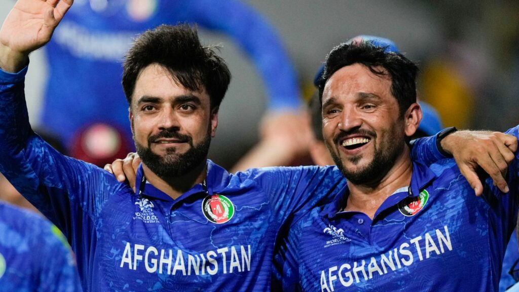 Afghanistan's captain Rashid Khan, left, and teammate Gulbadin Naib celebrate after defeating Bangladesh by eight runs in their men's T20 World Cup cricket match at Arnos Vale Ground, Kingstown, Saint Vincent and the Grenadines, Monday, June 24, 2024. (AP Photo/Ricardo Mazalan)